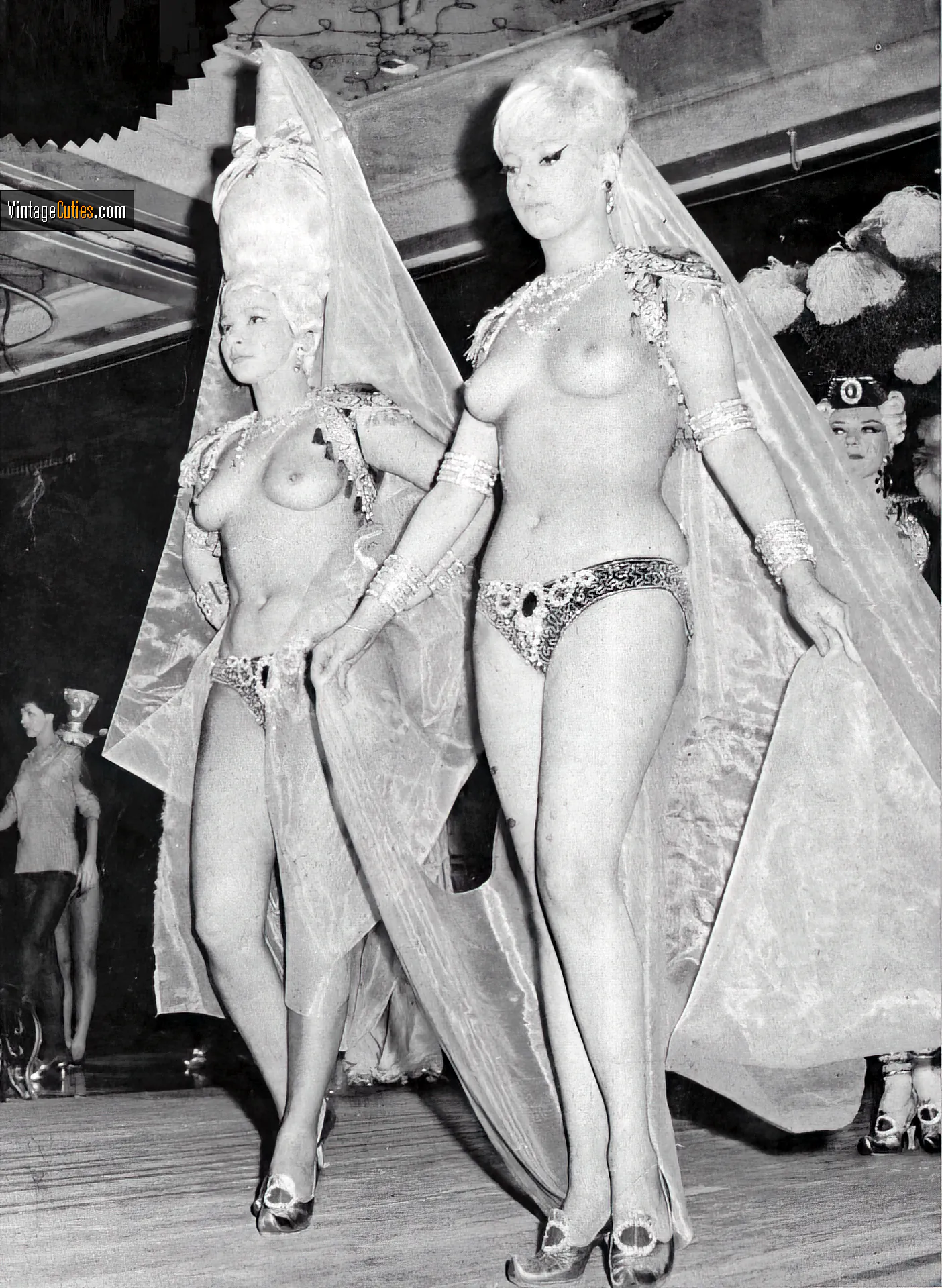 Extravagantly dressed topless vintage babes in a burlesque theatre