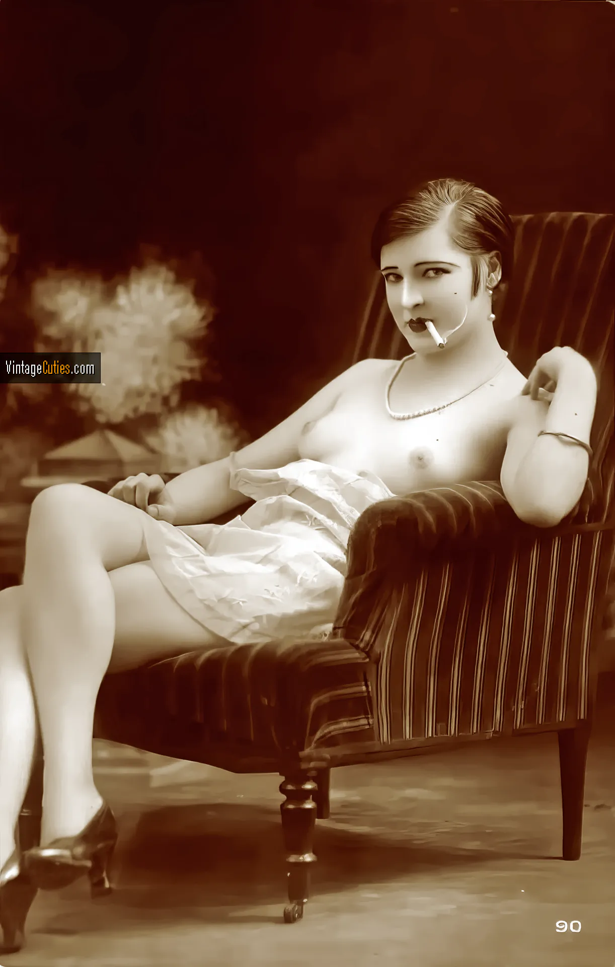 Pretty vintage diva with a bare chest smokes a cigarette
