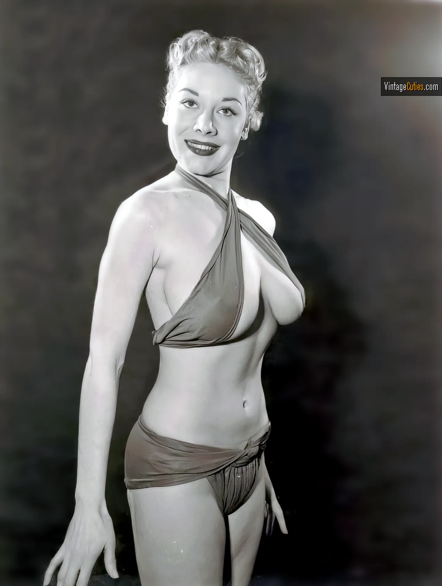 Hot vintage blonde poses in her bikini that barely covers her big tits