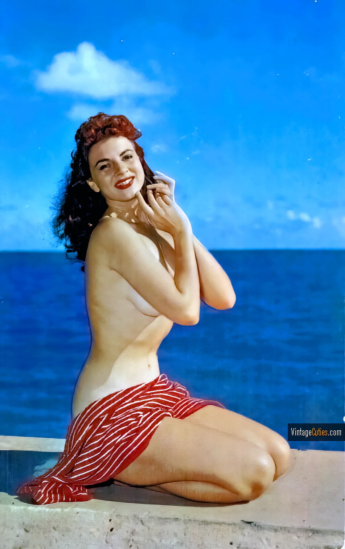 Jackie Miller poses on the beach and covers her curves